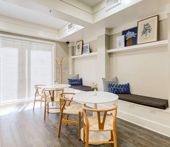 A dining room with a white table and chairs.