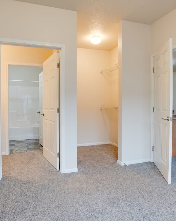 a bedroom with a door to a bathroom and a closet