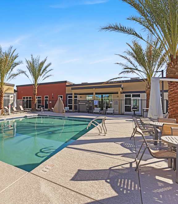 A pool surrounded by palm trees and sun loungers. at Agave House Apartments, Casa Grande, 85122