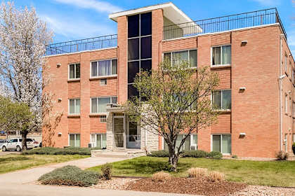 a brick building with a balcony and a sidewalk