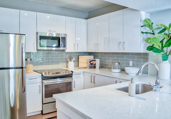 Well-appointed Kitchen with Quartz Countertops & Glass Backsplash at The Sophia at Abacoa, Jupiter