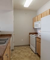 a hand holding a remote control in front of a television at Stetson Meadows Apartments, Colorado Springs, CO, 80922