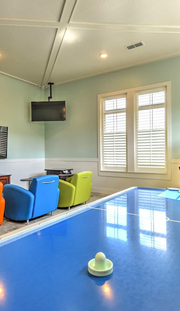 a game room with a ping pong table and a video game