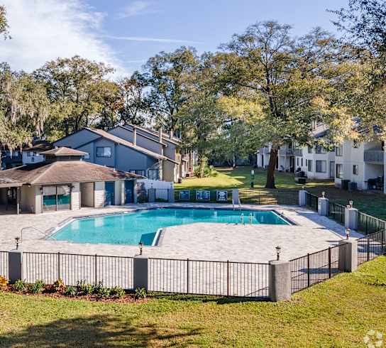 a swimming pool with a fence around it in front of a house