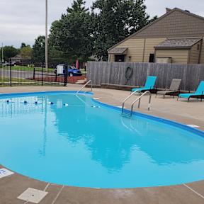 Willow Creek Apartments - Pool area with lounge chairs and clear water.