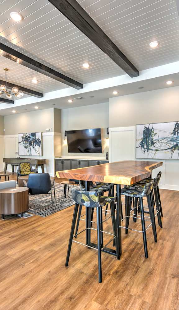 A modern room with a wooden floor and a bar area.