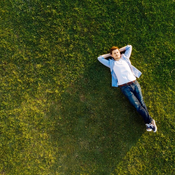 a woman laying on the grass in a park