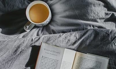 Coffee and book on bed
