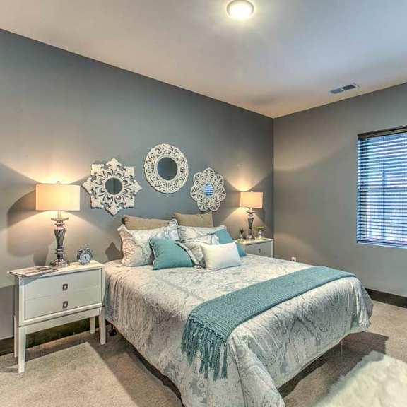 bedroom with dark gray walls and light toned furniture