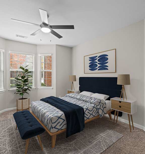 A bedroom with a bed, nightstand, and a ceiling fan.