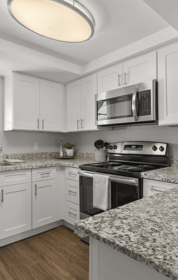 a kitchen with granite counter tops and white cabinets at Vaseo Apartments, Phoenix