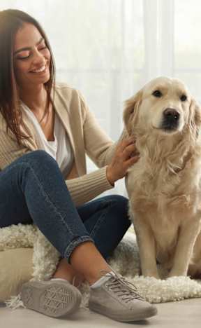 A woman is sitting on a white rug with her dog. at Hallwood Manor Apartments, Mentor, 44060