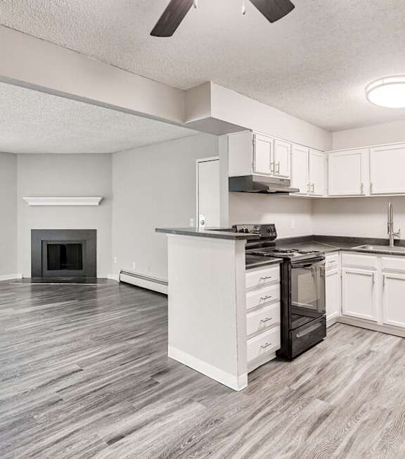 A modern kitchen with a stove, microwave, and sink.at Miramar Apartments, Denver