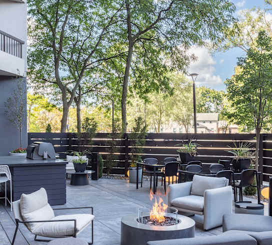 an outdoor patio with couches and chairs and a fire pit
