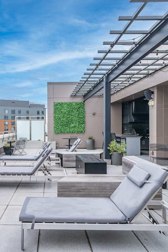 A rooftop patio with grey chairs and tables.