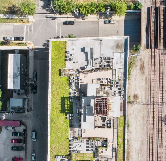 an aerial view of a city with a parking lot and grass