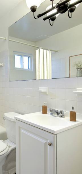A white bathroom with a mirror and a sink. at Northeast Villas, Fridley, 55421