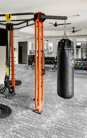 a gym with weights and cardio equipment in a building with windows