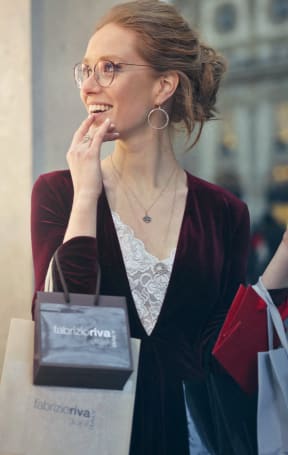 a woman talking on her cell phone while holding shopping bags