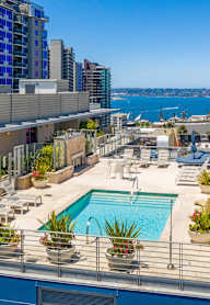 A rooftop pool area with a view of the city and water.