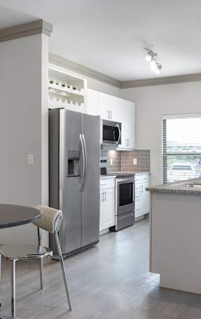 A modern kitchen with a black and white horse picture on the wall.