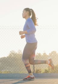 a woman running on a tennis court at sunset at Glen Haven Apts, San Gabriel, CA 91776