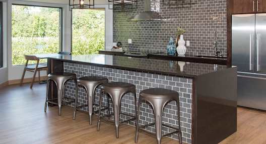 a kitchen with a large island with stools in front of it