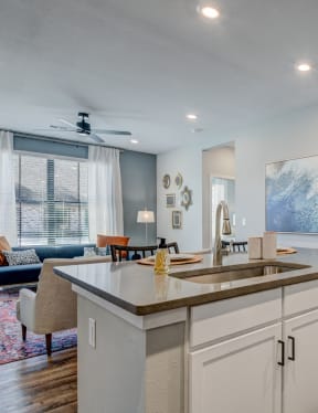 a kitchen with an island and a living room with a couch