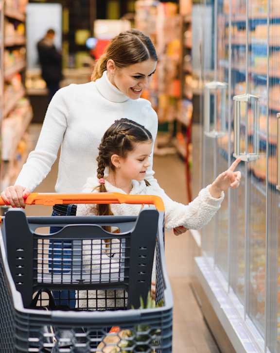 A woman and a child are shopping in a grocery store.