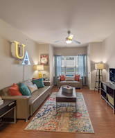 A living room with a couch, a rug, and a TV.