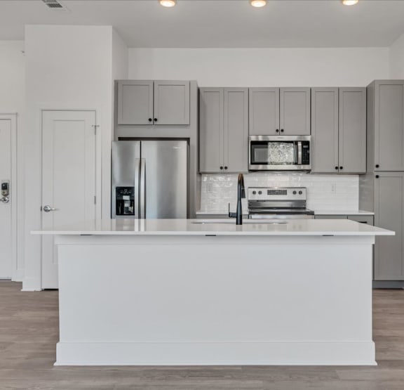 an empty living room with wood flooring and a white door  at Luxe 360 on Centerpointe Apartments, Virginia