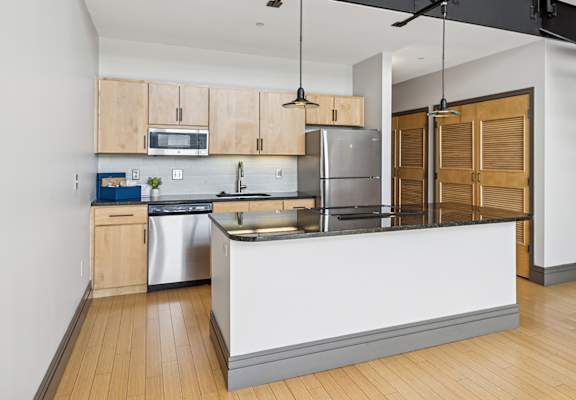 A modern kitchen with wooden cabinets and a white island.