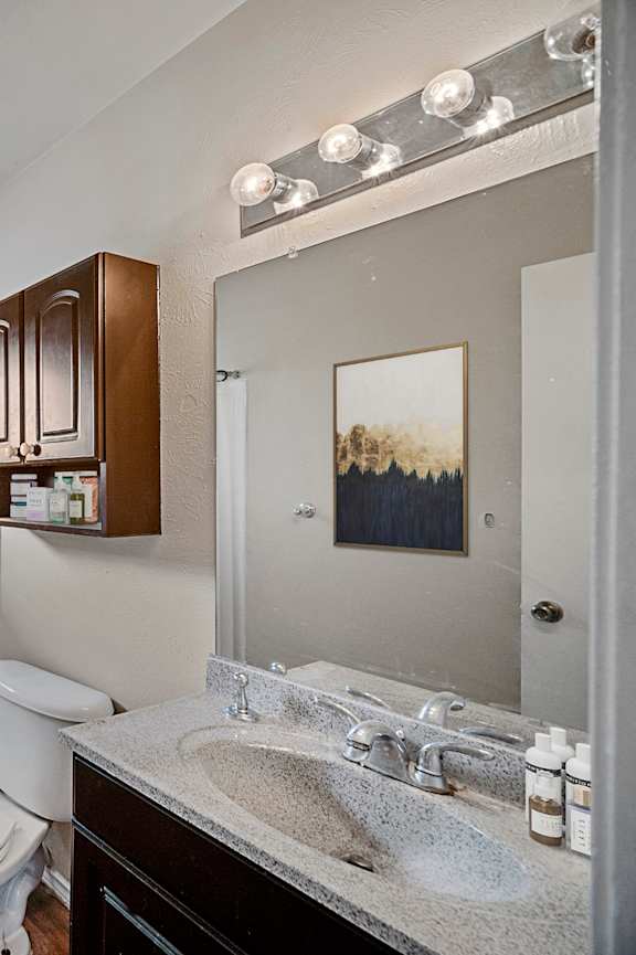 A white bathroom with a toilet, sink, and shower.