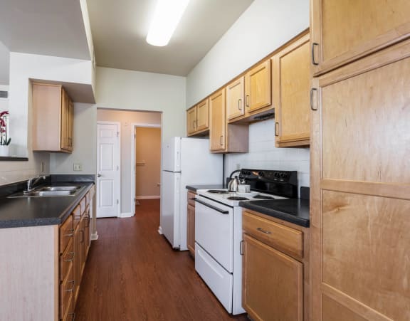 a kitchen with white appliances and wooden cabinets