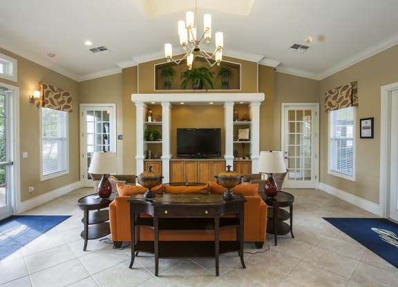 a large living room with a large tv on the wall and a large wooden table in the