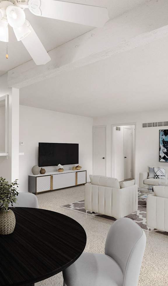a living room and dining room with white furniture and a black table