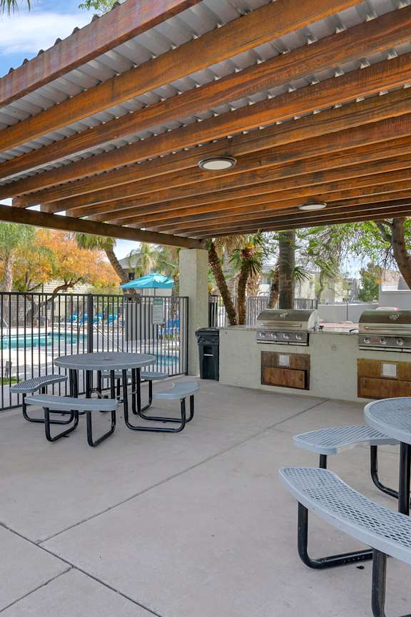A patio with a table and chairs under a roof.