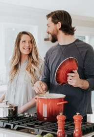 A man and woman are cooking together in a kitchen. at Crown Pointe, Lakewood, WA, 98499