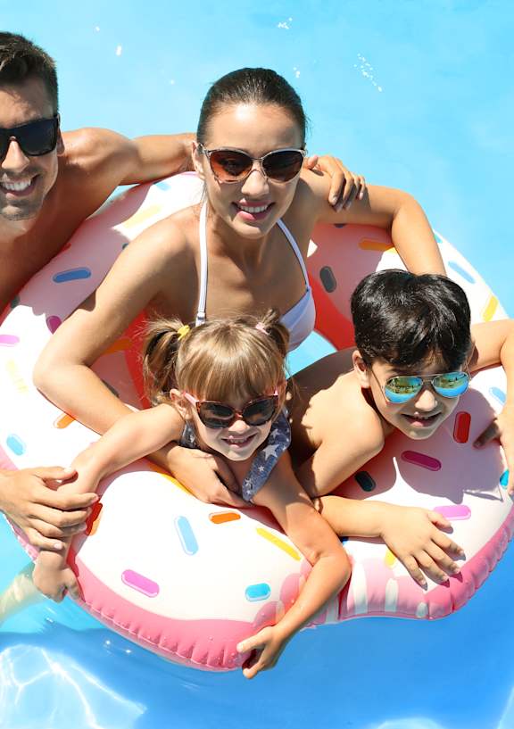 A family of four is enjoying a day in the pool.