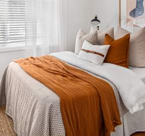 A bedroom with a bed, a nightstand, and a painting on the wall.