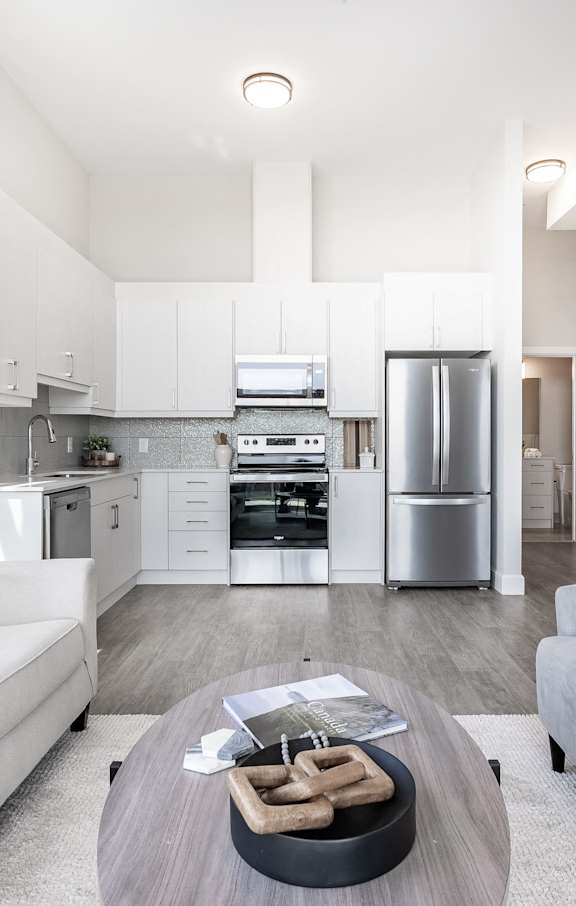 A modern kitchen with white cabinets and stainless steel appliances.