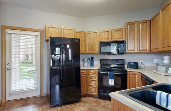 a kitchen with wooden cabinets and a black appliances