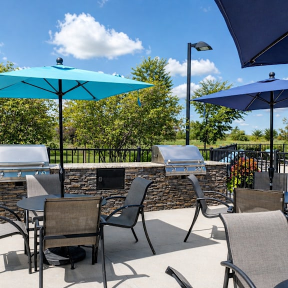 A patio with chairs and tables under umbrellas.