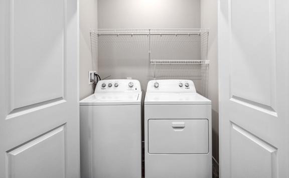 A white laundry room with a washer and dryer.