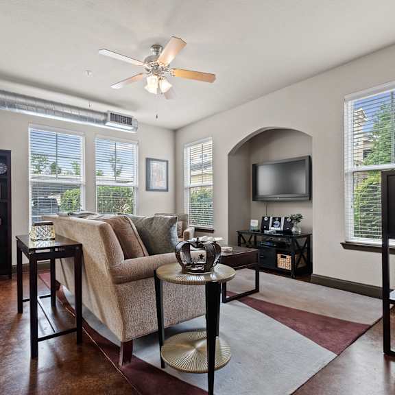 an open concept living room and dining area with a white dining table and rattan chairs at The Millennium Towne Center Apartments, Louisiana 70806