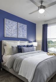 a blue and white bedroom with a bed and a ceiling fan