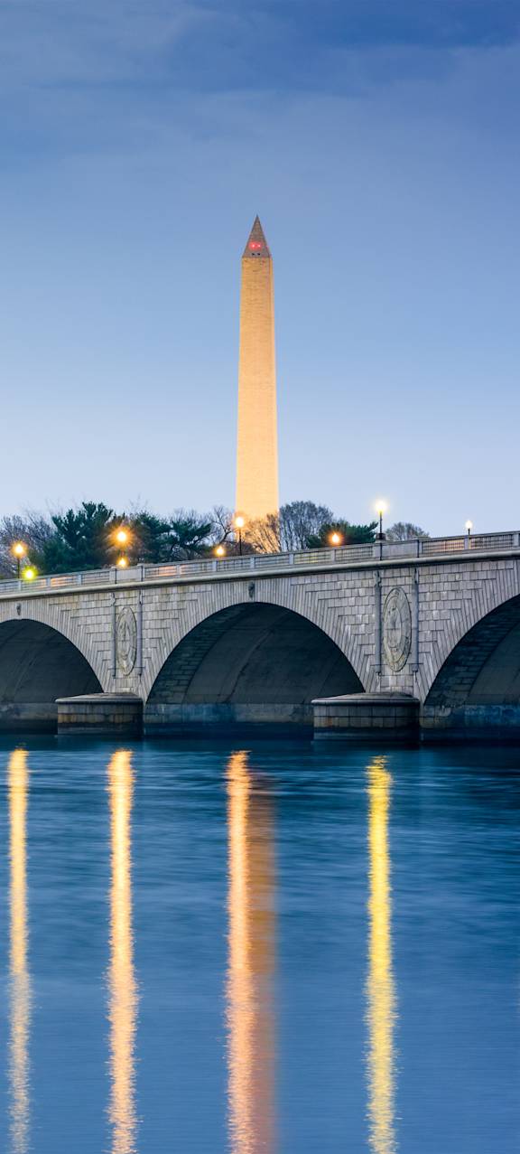 a bridge over a river with the monument in the background
