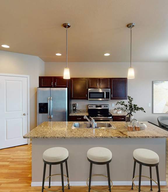 A kitchen with a bar area and a dining table.