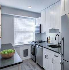 a kitchen with white cabinets and a stainless steel refrigerator