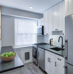 a kitchen with white cabinets and a stainless steel refrigerator